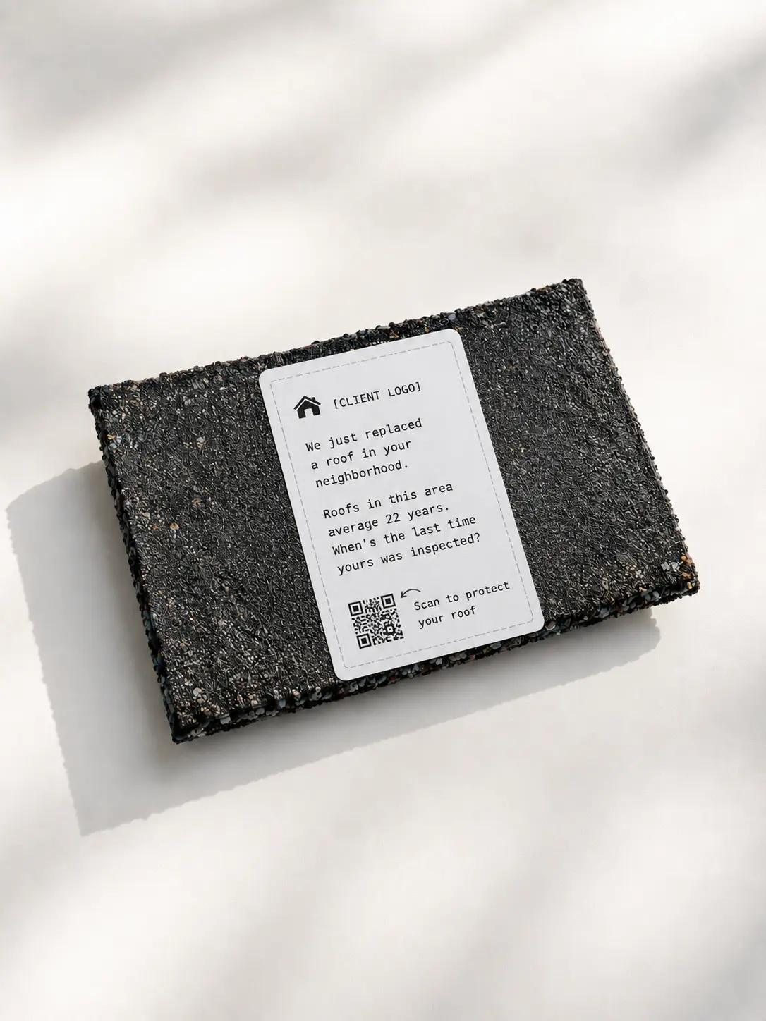 Hand holding open envelope with ShingleDrop shingle piece